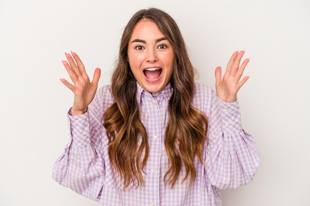 Young caucasian woman isolated on white background celebrating a victory or success, he is surprised and shocked.