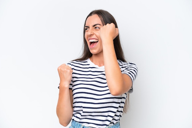 Young caucasian woman isolated on white background celebrating a victory