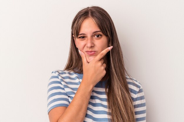 Giovane donna caucasica isolata su sfondo bianco contemplando, pianificando una strategia, pensando al modo di fare affari.