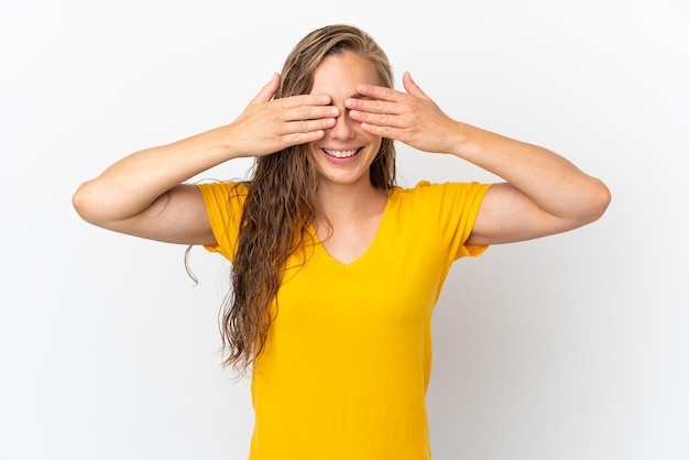 Young caucasian woman isolated on white background covering eyes by hands and smiling