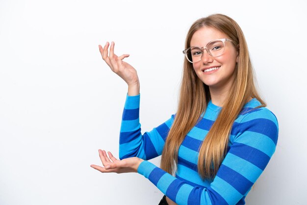 Young caucasian woman isolated on white background extending hands to the side for inviting to come