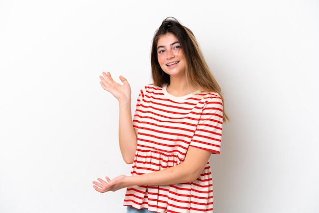 Young caucasian woman isolated on white background extending hands to the side for inviting to come