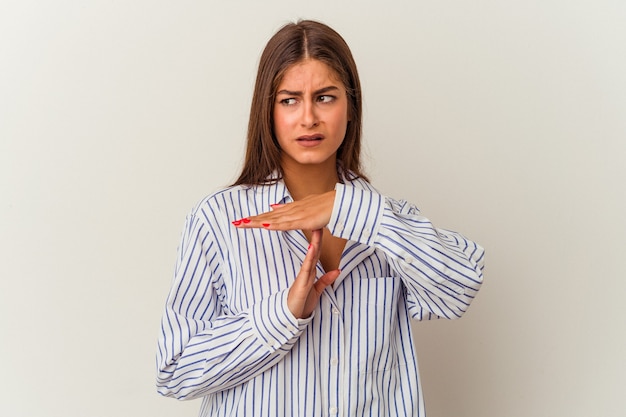 Young caucasian woman isolated on white background frowning face in displeasure, keeps arms folded.