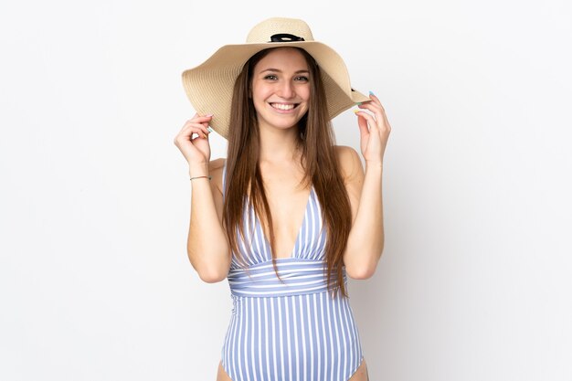 Young caucasian woman isolated on white background happy in swimsuit in summer holidays