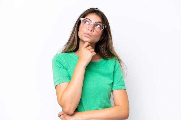 Young caucasian woman isolated on white background having doubts