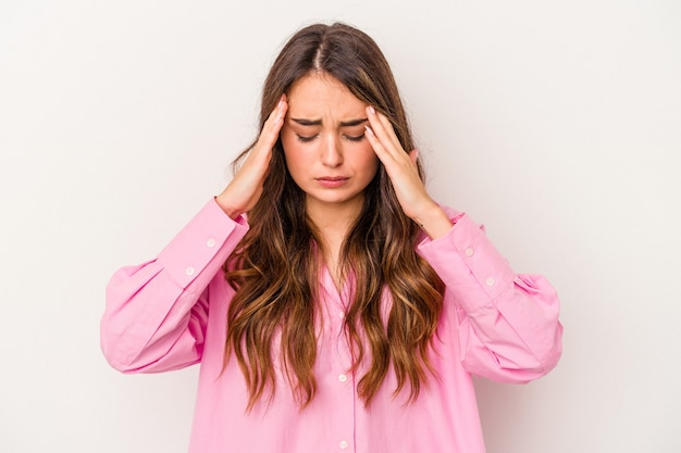 Young caucasian woman isolated on white background having a head ache, touching front of the face.