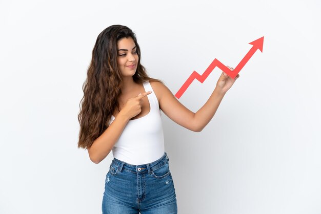 Young caucasian woman isolated on white background holding a catching a rising arrow and pointing it