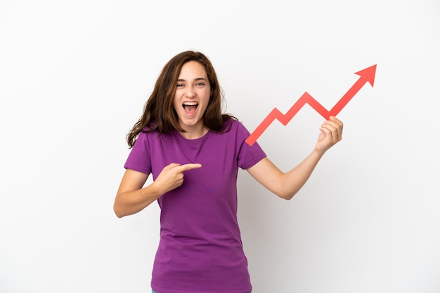 Young caucasian woman isolated on white background holding a catching a rising arrow with surprised expression