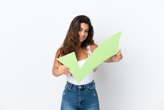 Young caucasian woman isolated on white background holding a check icon with happy expression