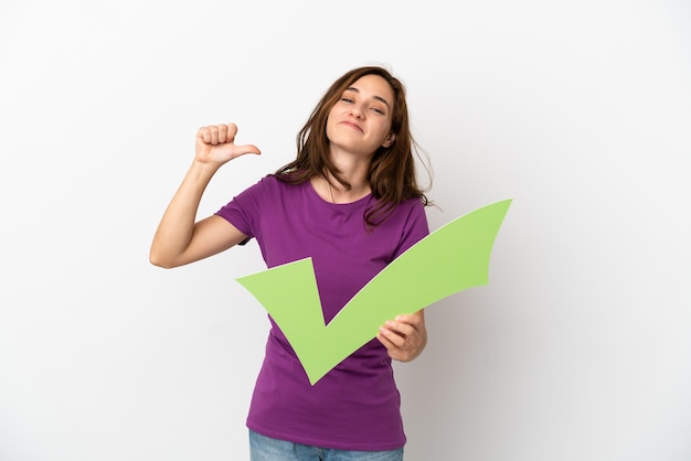 Young caucasian woman isolated on white background holding a check icon with proud gesture