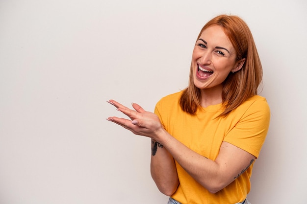 Young caucasian woman isolated on white background holding a copy space on a palm