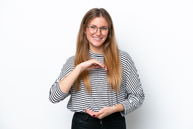 Young caucasian woman isolated on white background holding copyspace imaginary on the palm to insert an ad