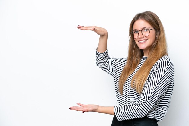 Young caucasian woman isolated on white background holding copyspace to insert an ad