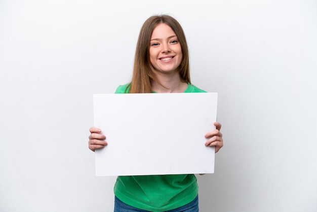 Young caucasian woman isolated on white background holding an empty placard with happy expression