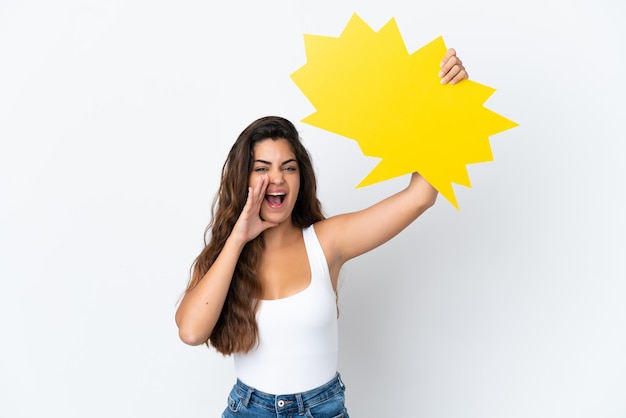 Young caucasian woman isolated on white background holding an empty speech bubble and shouting