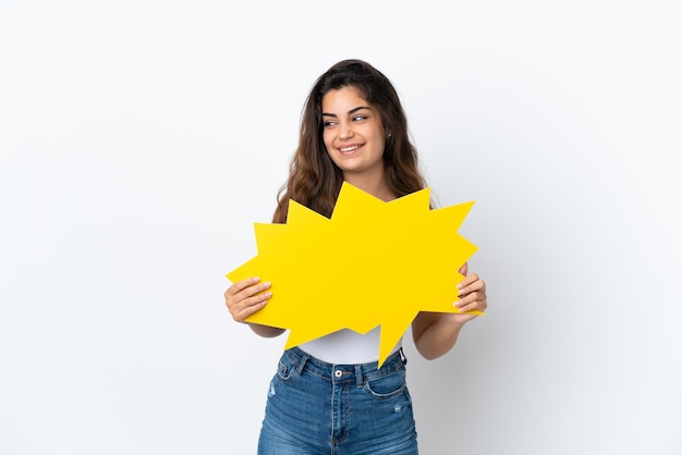 Young caucasian woman isolated on white background holding an empty speech bubble