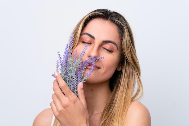 Young caucasian woman isolated on white background holding a lavender plant Close up portrait