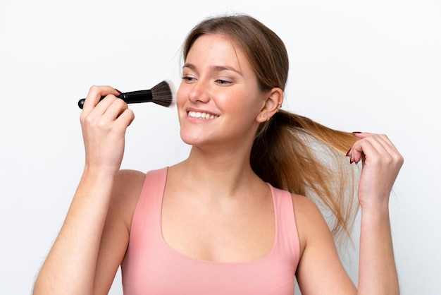 Young caucasian woman isolated on white background holding makeup brush