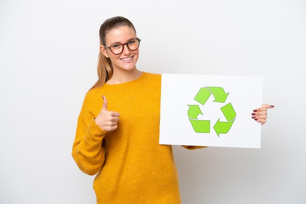 Young caucasian woman isolated on white background holding a placard with recycle icon with thumb up