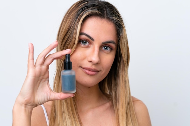 Young caucasian woman isolated on white background holding a serum Close up portrait