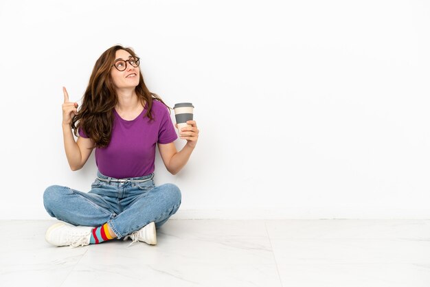 Young caucasian woman isolated on white background intending to realizes the solution while lifting a finger up