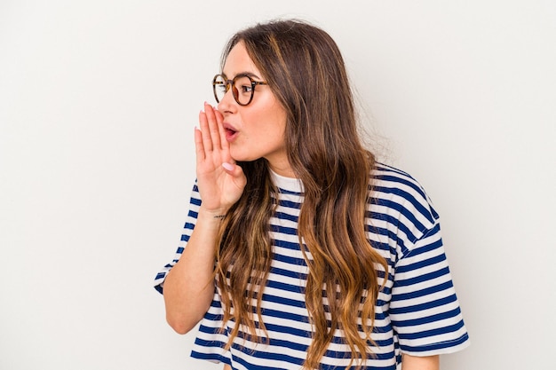 Young caucasian woman isolated on white background is saying a secret hot braking news and looking aside