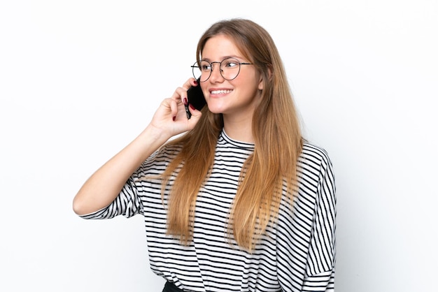 Young caucasian woman isolated on white background keeping a conversation with the mobile phone