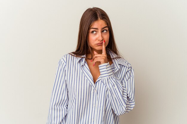 Young caucasian woman isolated on white background looking sideways with doubtful and skeptical expression.