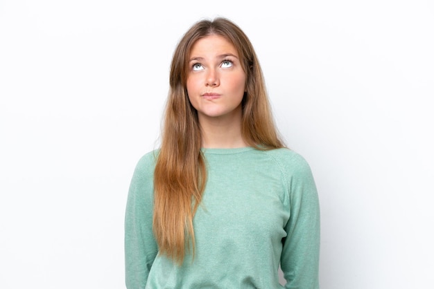 Young caucasian woman isolated on white background and looking up