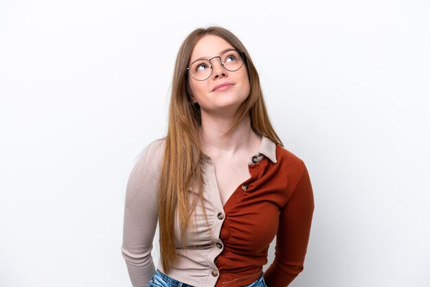 Young caucasian woman isolated on white background and looking up