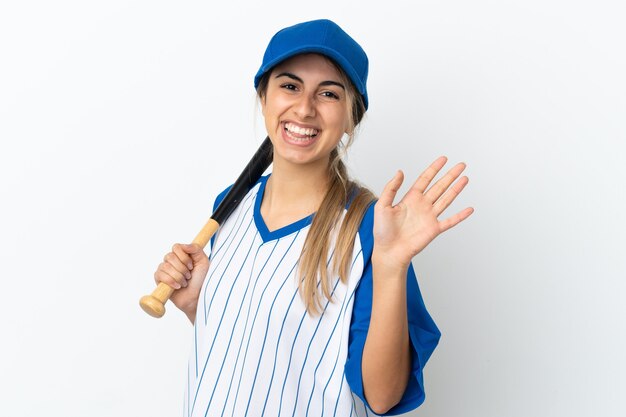 Young caucasian woman isolated on white background playing baseball and saluting with hand