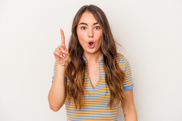 Young caucasian woman isolated on white background pointing upside with opened mouth.