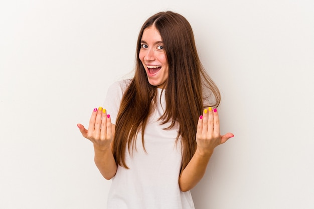 Young caucasian woman isolated on white background pointing with finger at you as if inviting come closer.