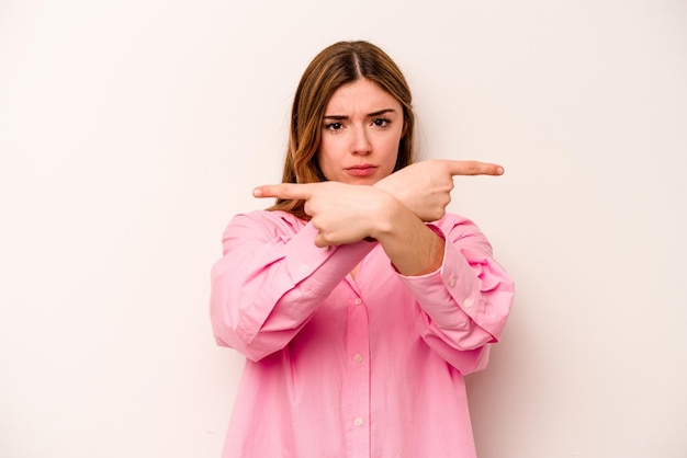 Young caucasian woman isolated on white background points sideways is trying to choose between two options