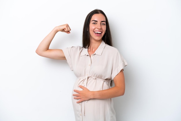 Young caucasian woman isolated on white background pregnant and doing strong gesture