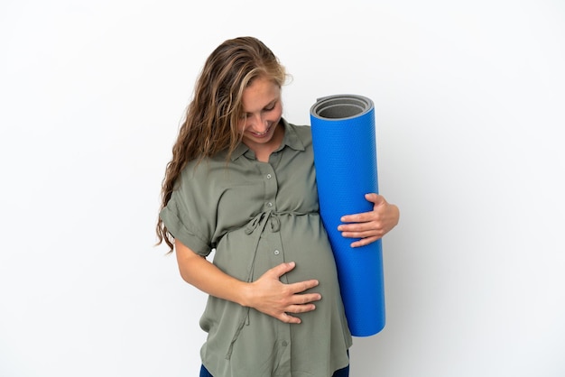 Young caucasian woman isolated on white background pregnant and going to yoga classes