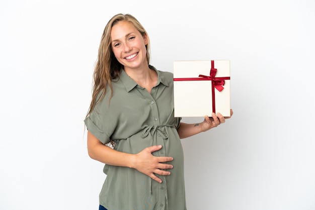 Young caucasian woman isolated on white background pregnant and holding a gift