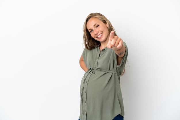 Young caucasian woman isolated on white background pregnant and pointing to the front