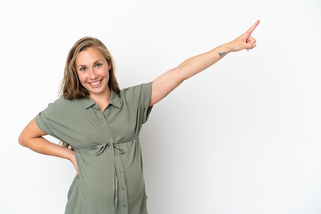 Young caucasian woman isolated on white background pregnant and pointing to the lateral