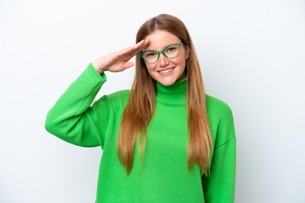 Young caucasian woman isolated on white background saluting with hand with happy expression