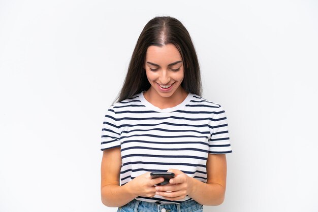 Young caucasian woman isolated on white background sending a message with the mobile