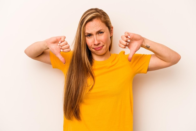 Young caucasian woman isolated on white background showing
thumb down disappointment concept