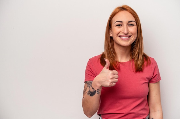 Young caucasian woman isolated on white background smiling and raising thumb up