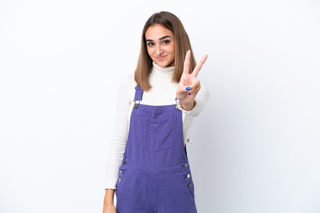 Young caucasian woman isolated on white background smiling and showing victory sign