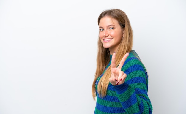 Young caucasian woman isolated on white background smiling and showing victory sign