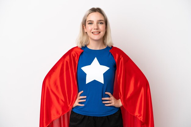 Young caucasian woman isolated on white background in superhero costume posing with arms at hip and smiling