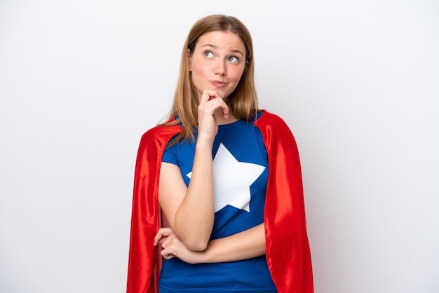 Young caucasian woman isolated on white background in superhero costume and thinking