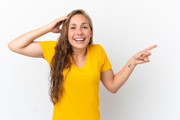 Young caucasian woman isolated on white background surprised and pointing finger to the side