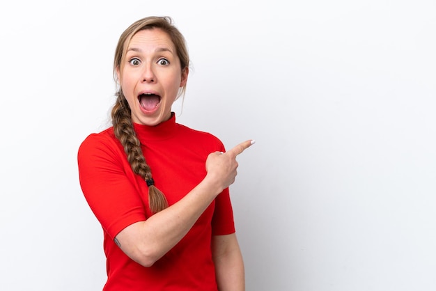 Young caucasian woman isolated on white background surprised and pointing side