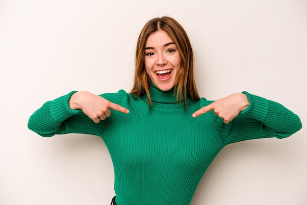 Young caucasian woman isolated on white background surprised pointing with finger smiling broadly